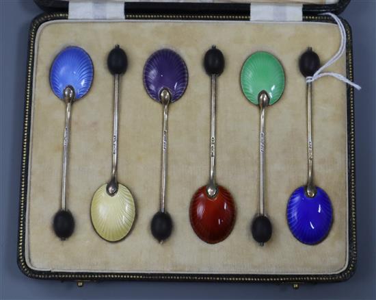 A cased set of six George V silver and polychrome enamel bean end coffee spoons.